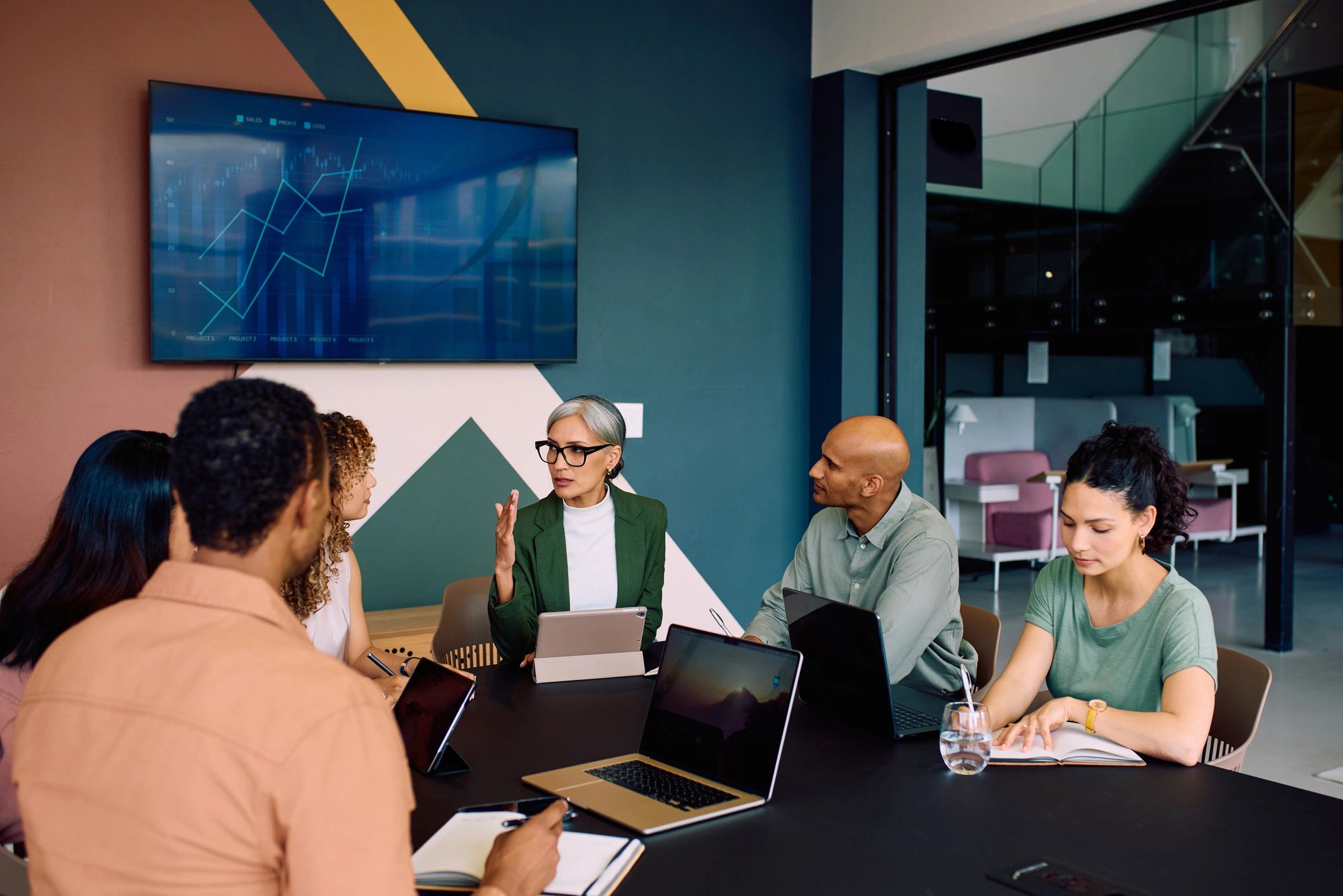 Wide shot of multiracial business team meeting together in office conference room